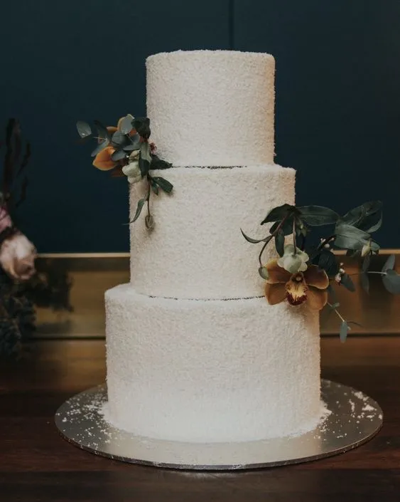 Three-tier textured custom cake with a sugar orchid and eucalyptus