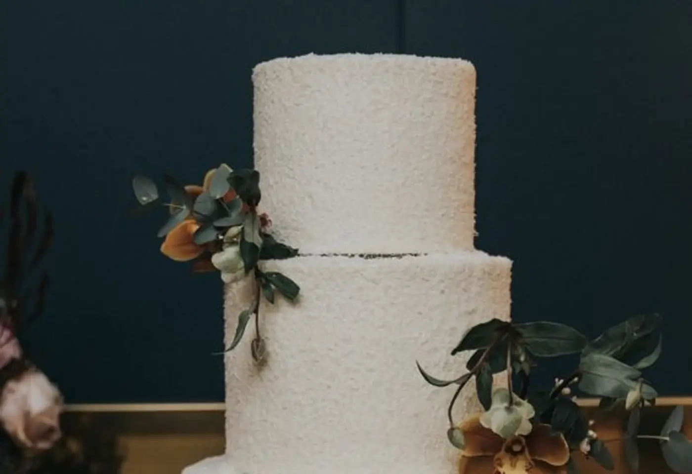 Textured buttercream custom cake tiers with orchid and eucalyptus styling