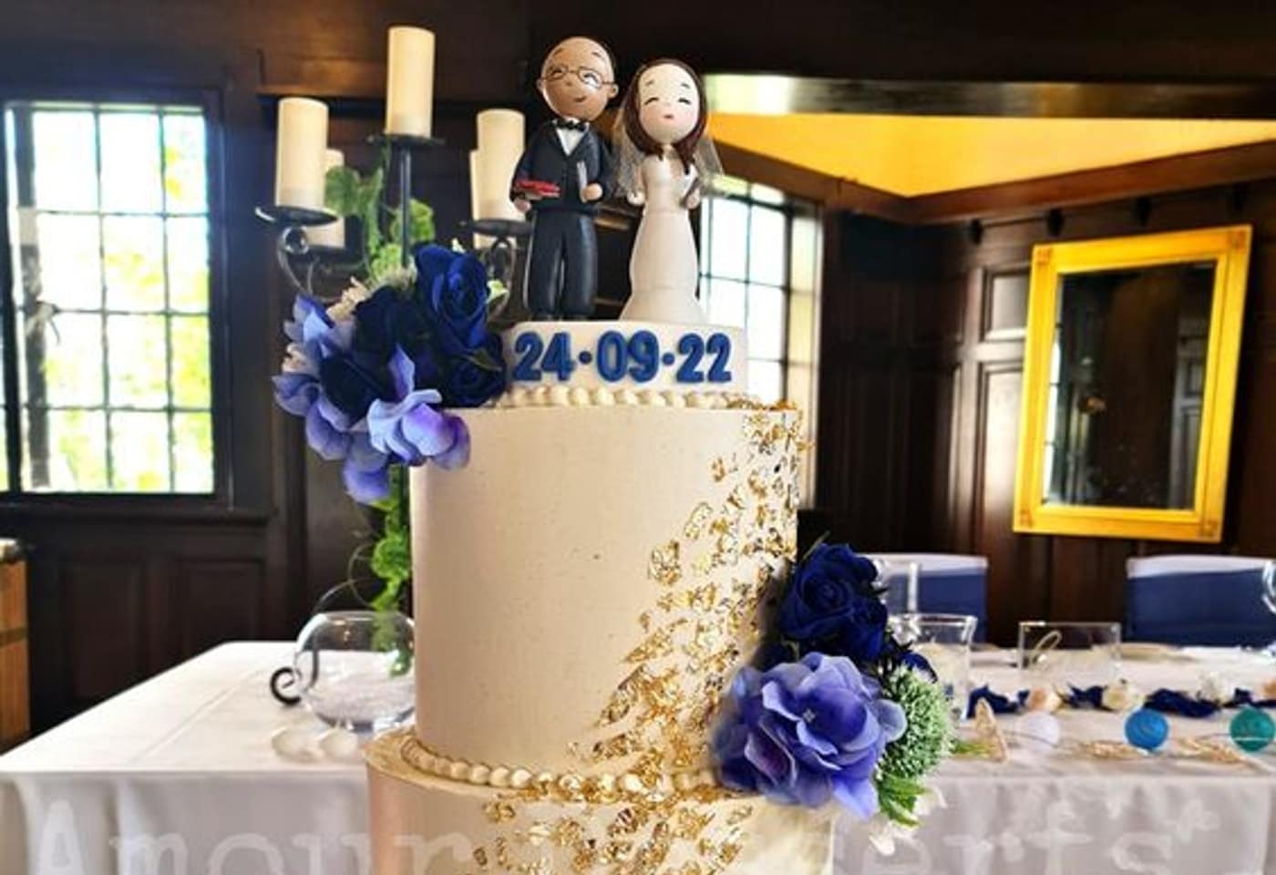 custom cake with gold leaf and blue florals on the cake table of a heritage reception room